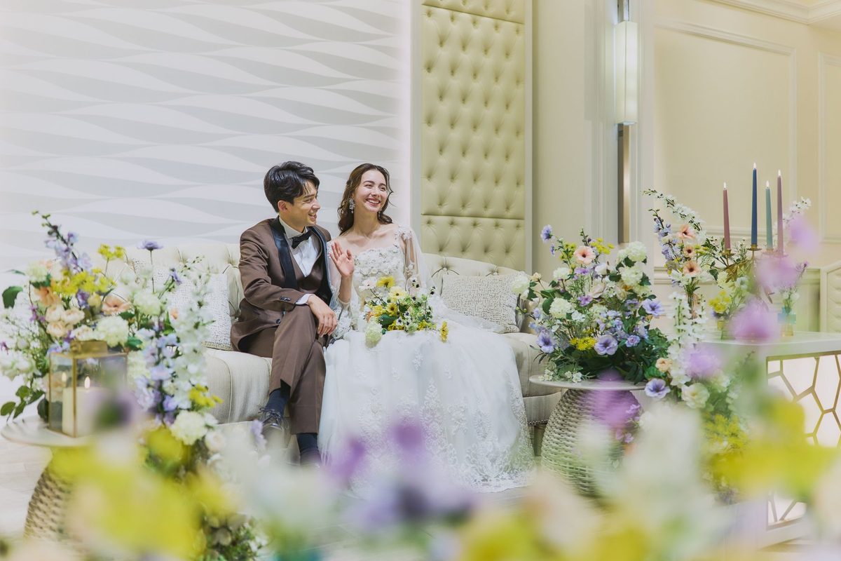 披露宴会場の高砂で笑顔を見せる新郎新婦